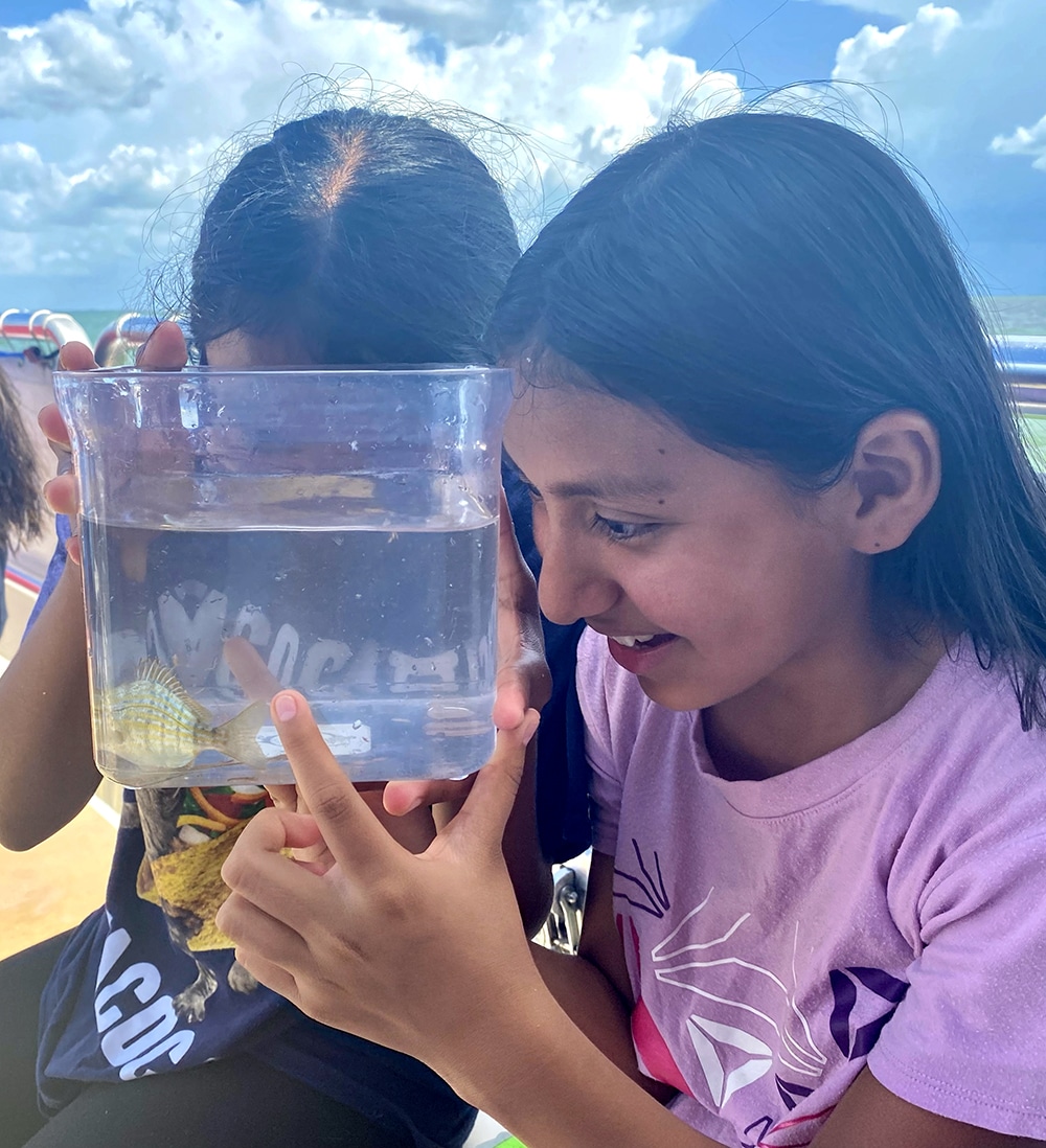 image of two girls looking at a fish