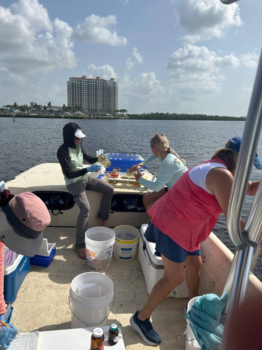 people sampling algae on boat