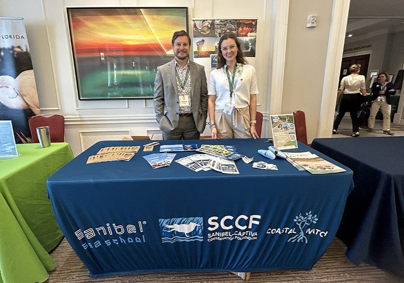 everglades conference 2024, two staff stand at SCCF table indoors